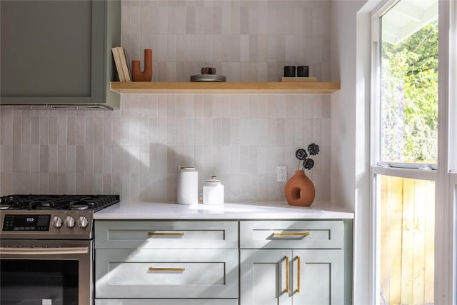 kitchen featuring decorative backsplash, gray cabinets, and stainless steel range with gas stovetop