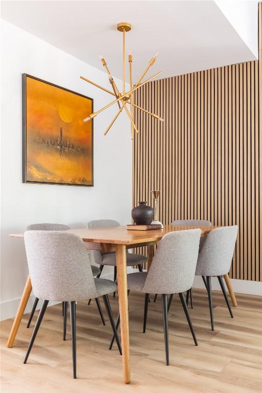 dining space featuring light wood-type flooring and a chandelier