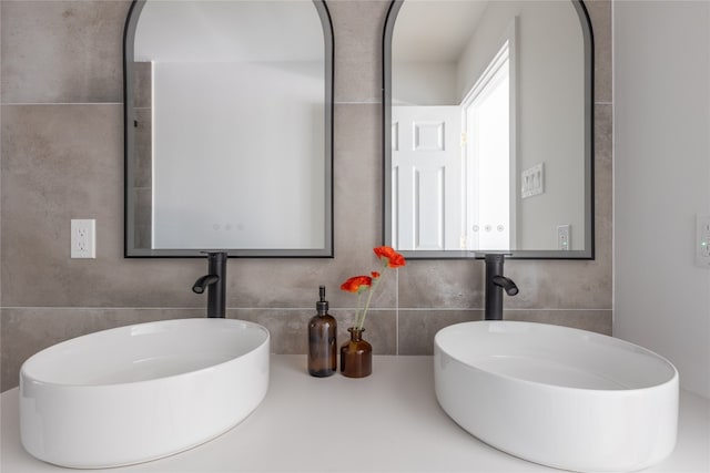 bathroom featuring decorative backsplash, vanity, and tile walls