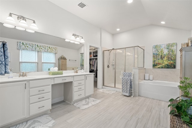 bathroom featuring vanity, lofted ceiling, hardwood / wood-style floors, and separate shower and tub