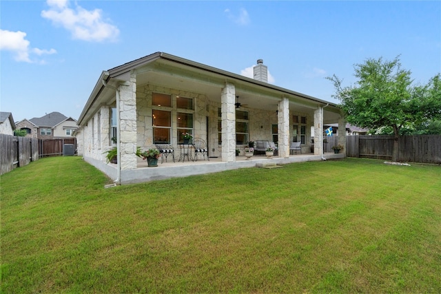 rear view of house with ceiling fan, a yard, a patio, and central AC unit