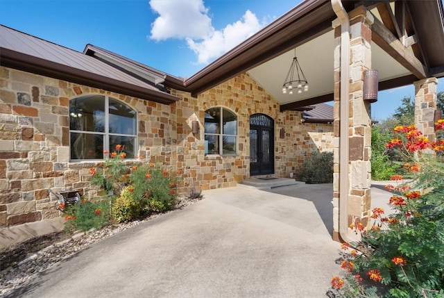 4408 Blacksmith Cv, Spicewood, TX 78669 - view of exterior entry featuring stone siding, a standing seam roof, and a metal roof