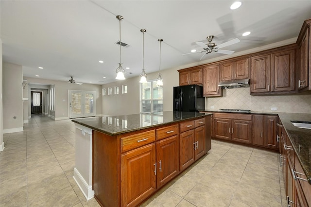 kitchen featuring ceiling fan, a kitchen island, black fridge with ice dispenser, and dark stone counters