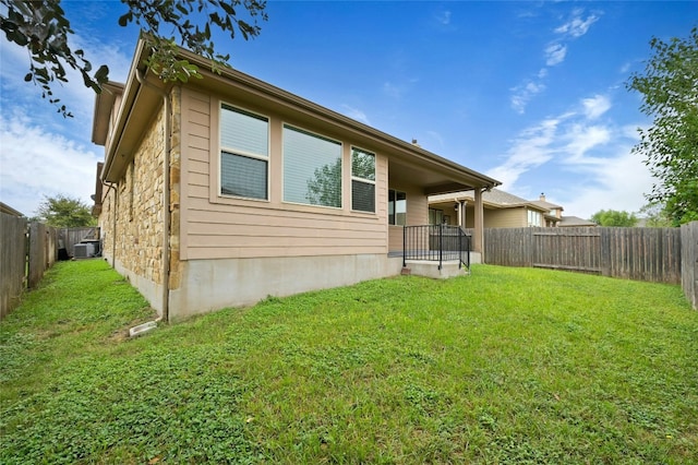 back of property featuring a yard and central AC unit