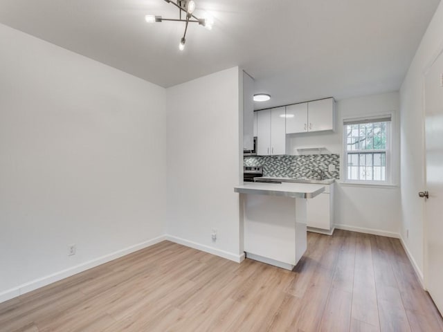 300 Crockett St Unit 103, Austin, TX 78704 - kitchen with white cabinetry, light wood finished floors, light countertops, and tasteful backsplash