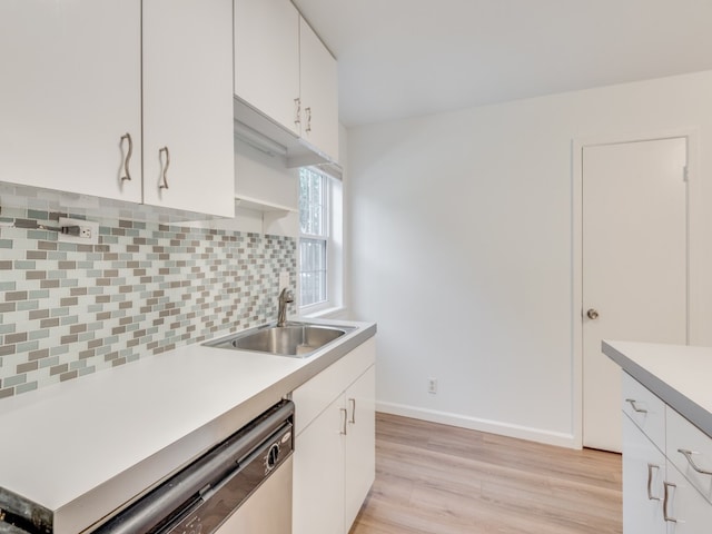 kitchen with white cabinets, dishwasher, light wood-type flooring, and sink