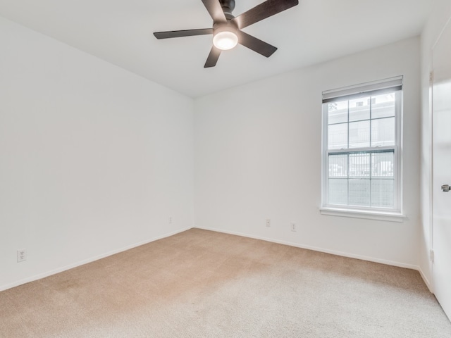 carpeted spare room with ceiling fan