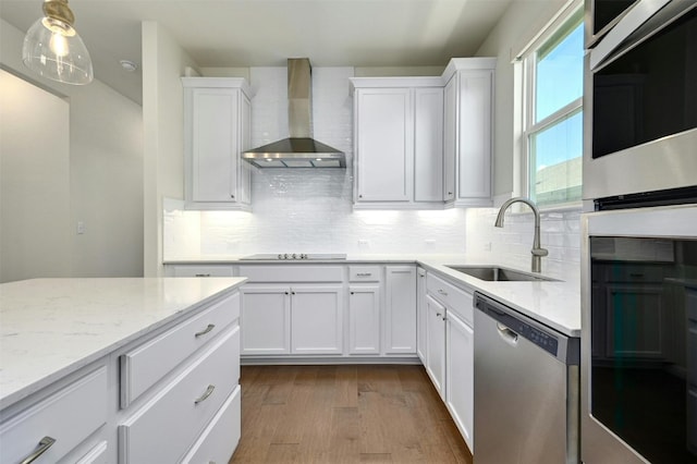 kitchen featuring wall chimney exhaust hood, stainless steel dishwasher, and white cabinets