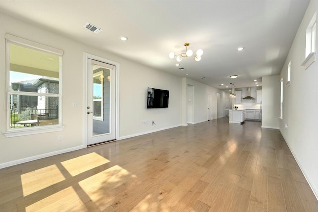 unfurnished living room featuring a chandelier and hardwood / wood-style flooring