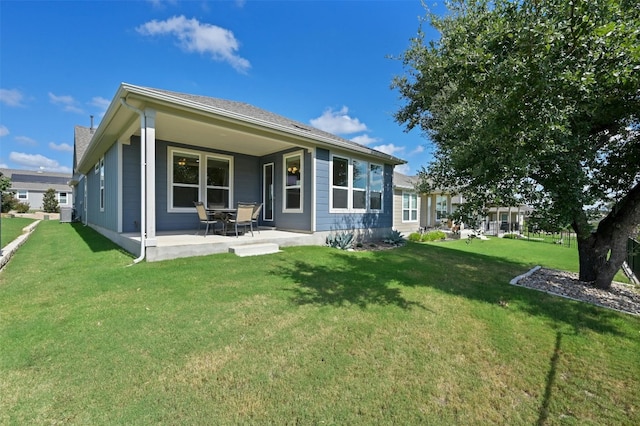 back of property featuring a lawn and a patio area