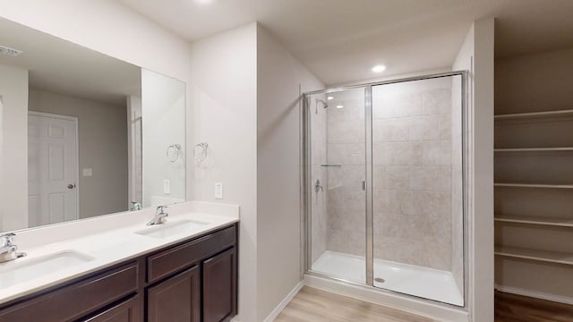 bathroom with vanity, hardwood / wood-style floors, and a shower with shower door