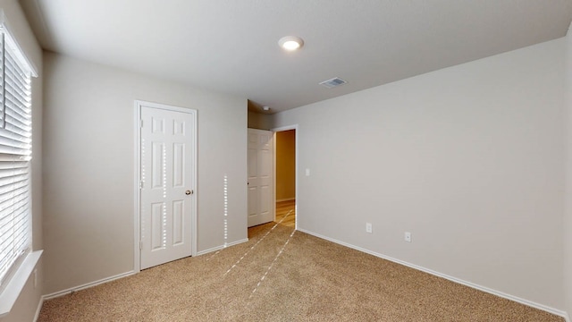 unfurnished bedroom featuring multiple windows and light colored carpet