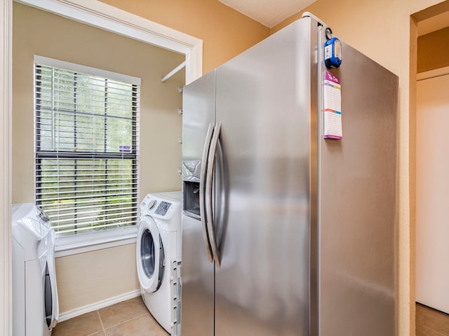 laundry room featuring light tile patterned floors and washing machine and clothes dryer