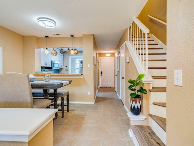 foyer with a textured ceiling, light tile patterned floors, and a chandelier