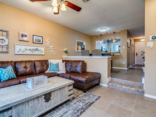 living room with ceiling fan, light tile patterned floors, and a textured ceiling