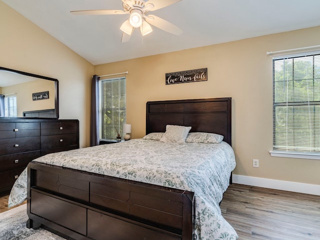 bedroom featuring light hardwood / wood-style floors, vaulted ceiling, and ceiling fan