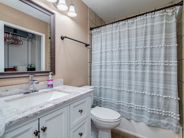 full bathroom featuring shower / bath combination with curtain, vanity, toilet, a textured ceiling, and tile patterned flooring