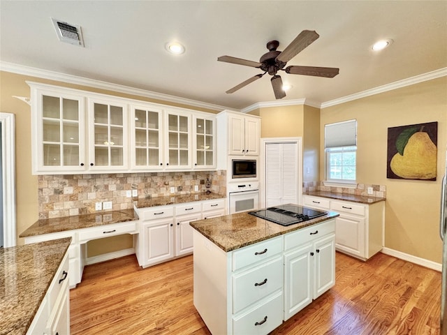 kitchen with ceiling fan, white oven, stainless steel microwave, and white cabinets