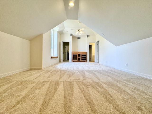 interior space featuring ceiling fan, light colored carpet, and lofted ceiling