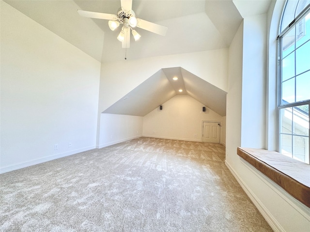 additional living space featuring vaulted ceiling, light carpet, and ceiling fan