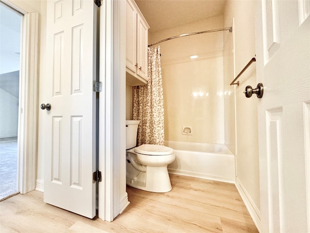 bathroom with wood-type flooring, shower / bath combination with curtain, and toilet