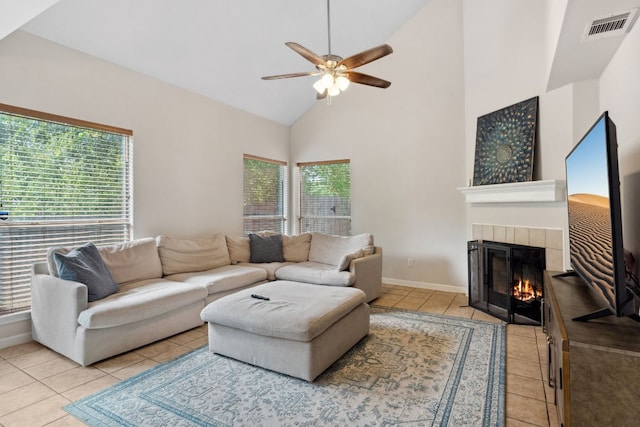 living room with a wealth of natural light, a fireplace, high vaulted ceiling, and ceiling fan