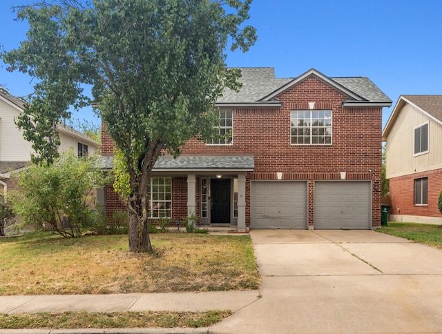 view of front of property featuring a front yard and a garage