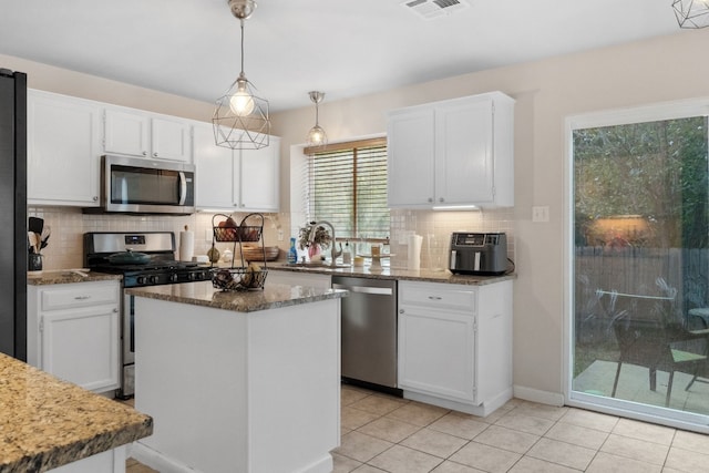 kitchen with white cabinets, a center island, and stainless steel appliances