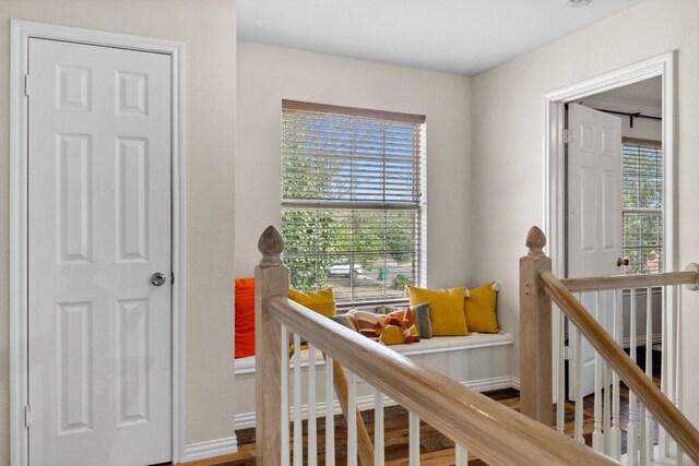 corridor with hardwood / wood-style flooring