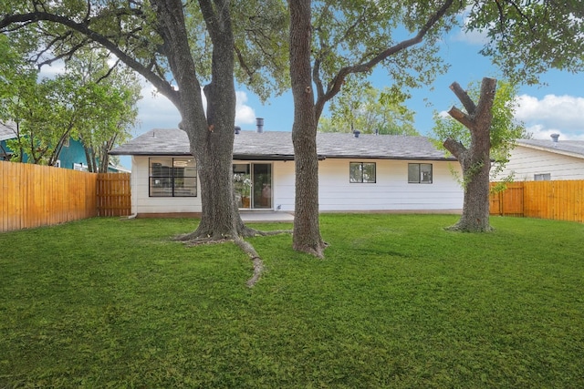 rear view of property with a lawn