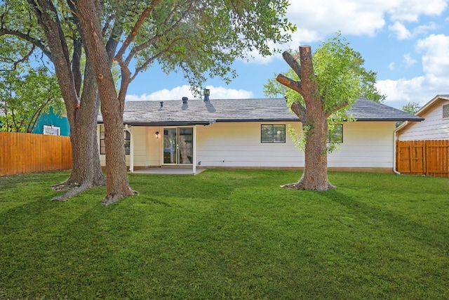 rear view of property featuring a lawn and a patio area