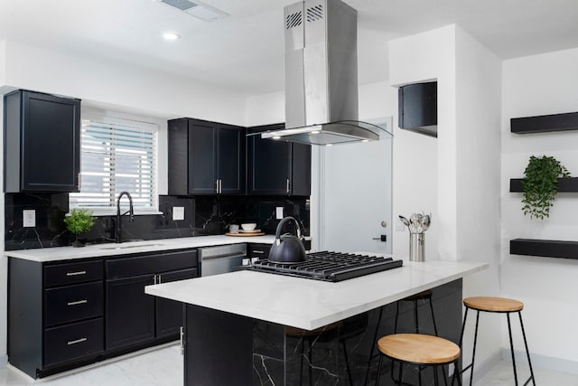 kitchen with backsplash, a breakfast bar, sink, and wall chimney range hood