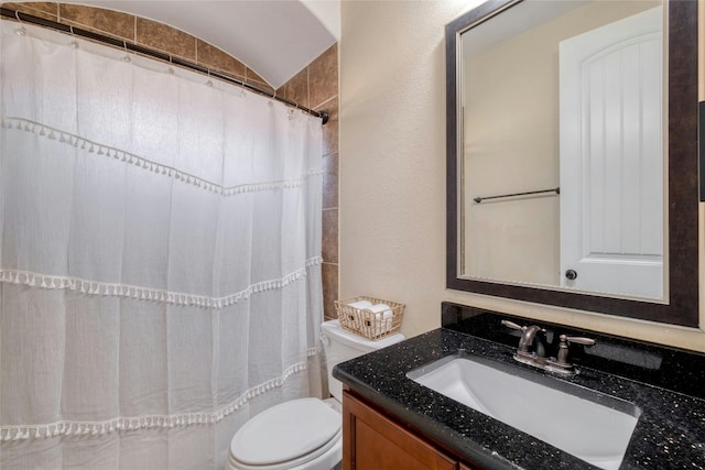 bathroom with vaulted ceiling, curtained shower, vanity, and toilet