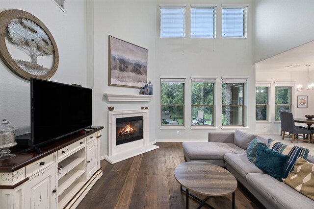 living room with a high ceiling, dark hardwood / wood-style flooring, and a notable chandelier