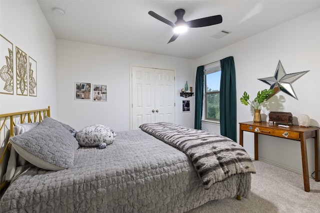 bedroom with ceiling fan, light colored carpet, and a closet