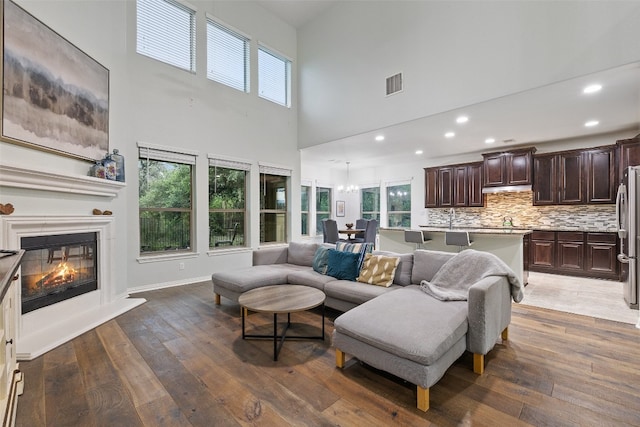 living room with a healthy amount of sunlight, dark wood-type flooring, and sink