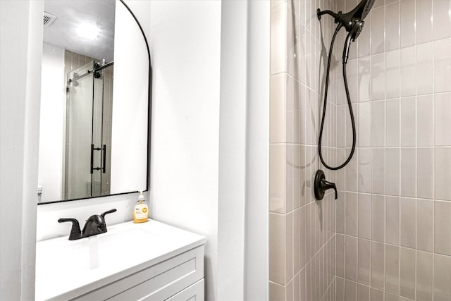 bathroom with vanity and a shower with shower door