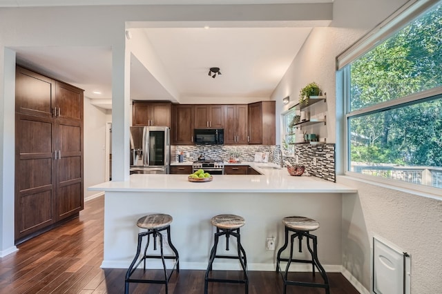 kitchen with stainless steel appliances, dark wood-type flooring, a healthy amount of sunlight, and sink