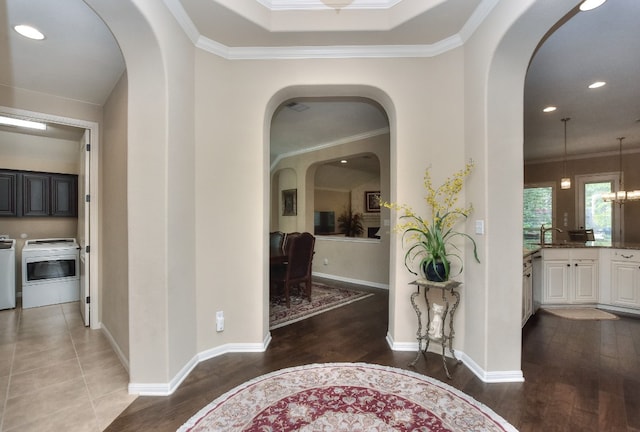 hall featuring ornamental molding, washer and clothes dryer, and dark hardwood / wood-style flooring