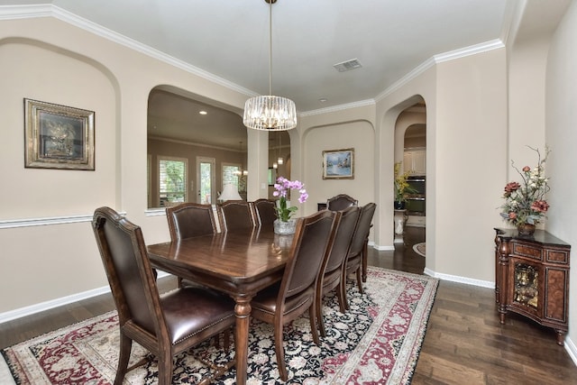 dining area with crown molding, dark wood-type flooring, and a chandelier