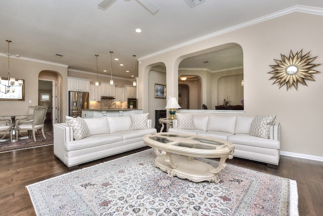 living room with sink, ceiling fan with notable chandelier, crown molding, and dark wood-type flooring