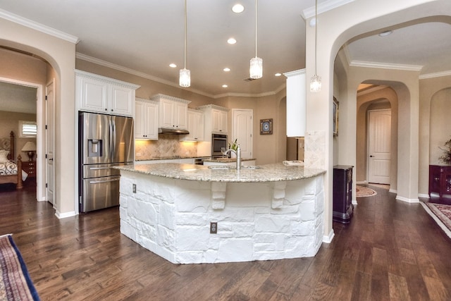 kitchen featuring appliances with stainless steel finishes, hanging light fixtures, white cabinets, dark hardwood / wood-style flooring, and light stone countertops