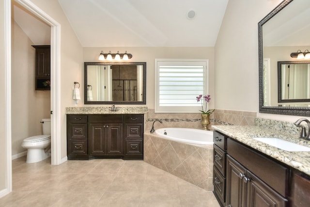 bathroom featuring lofted ceiling, tiled tub, tile patterned floors, vanity, and toilet