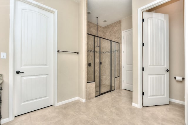 bathroom with a shower with door and tile patterned floors