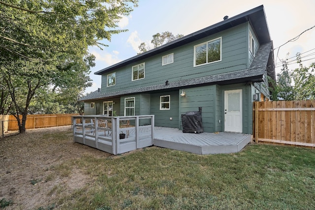 rear view of property with a yard and a deck