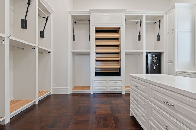 spacious closet featuring dark parquet floors