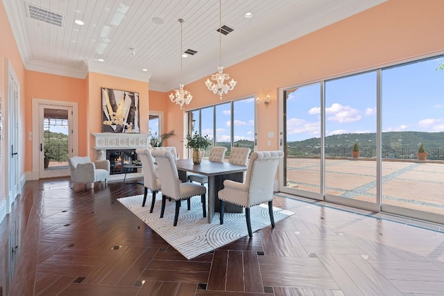 dining area featuring an inviting chandelier, ornamental molding, a mountain view, and dark parquet floors