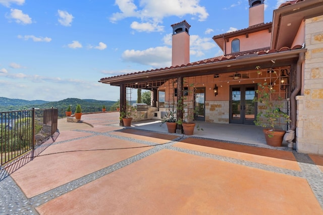 view of patio with a mountain view and french doors