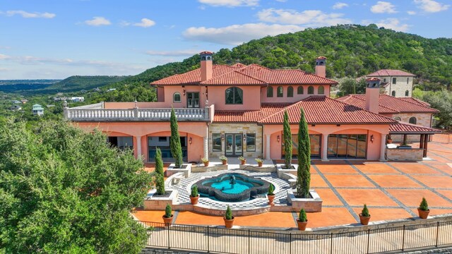 back of property featuring a balcony and a patio area