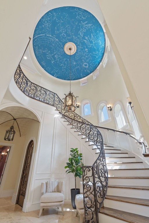 staircase featuring a notable chandelier and a high ceiling